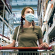 Shopper pushing cart at wholesale grocery store with face mask on